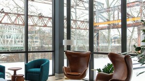 Een modern interieur met grote ramen, een centrale salontafel en twee stoelen.