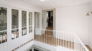 Un'ampia stanza con soffitto alto, pareti bianche e pavimento in legno.