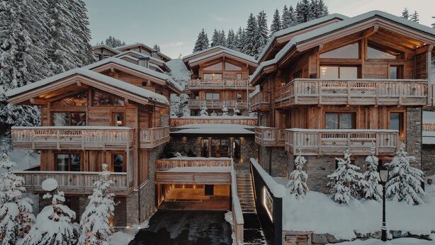 Een ruime houten chalets met meerdere balkons en een centrale ingang.