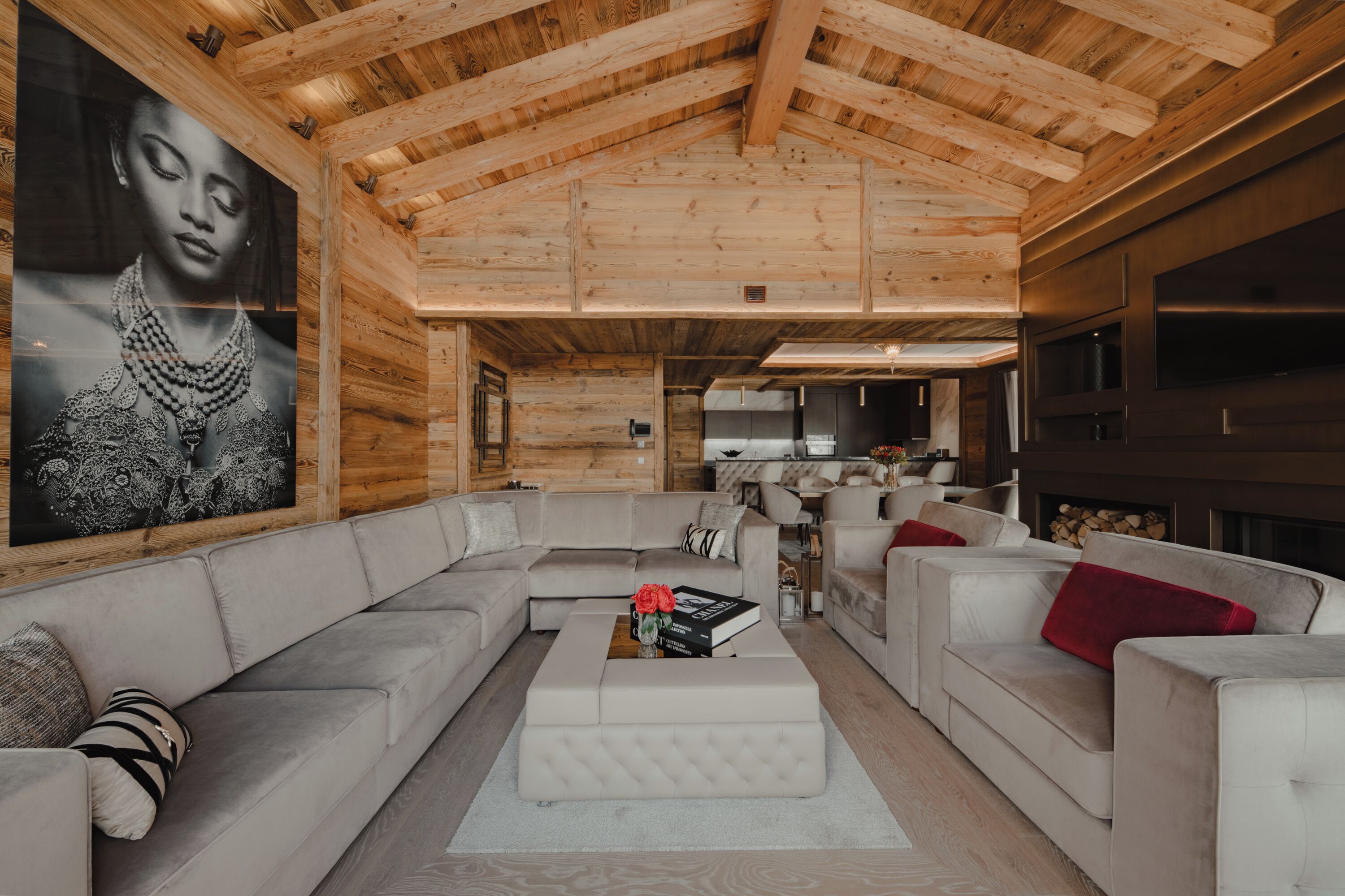Interior moderno de cabana de toras, com um amplo sofá modular, uma mesa de centro e uma lareira.