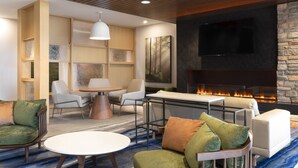 Una sala de estar moderna con chimenea, asientos cómodos y televisor.