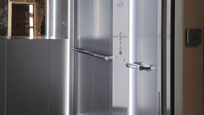 A modern elevator with stainless steel doors and a control panel. - Hanomag Quartier (Hannover)