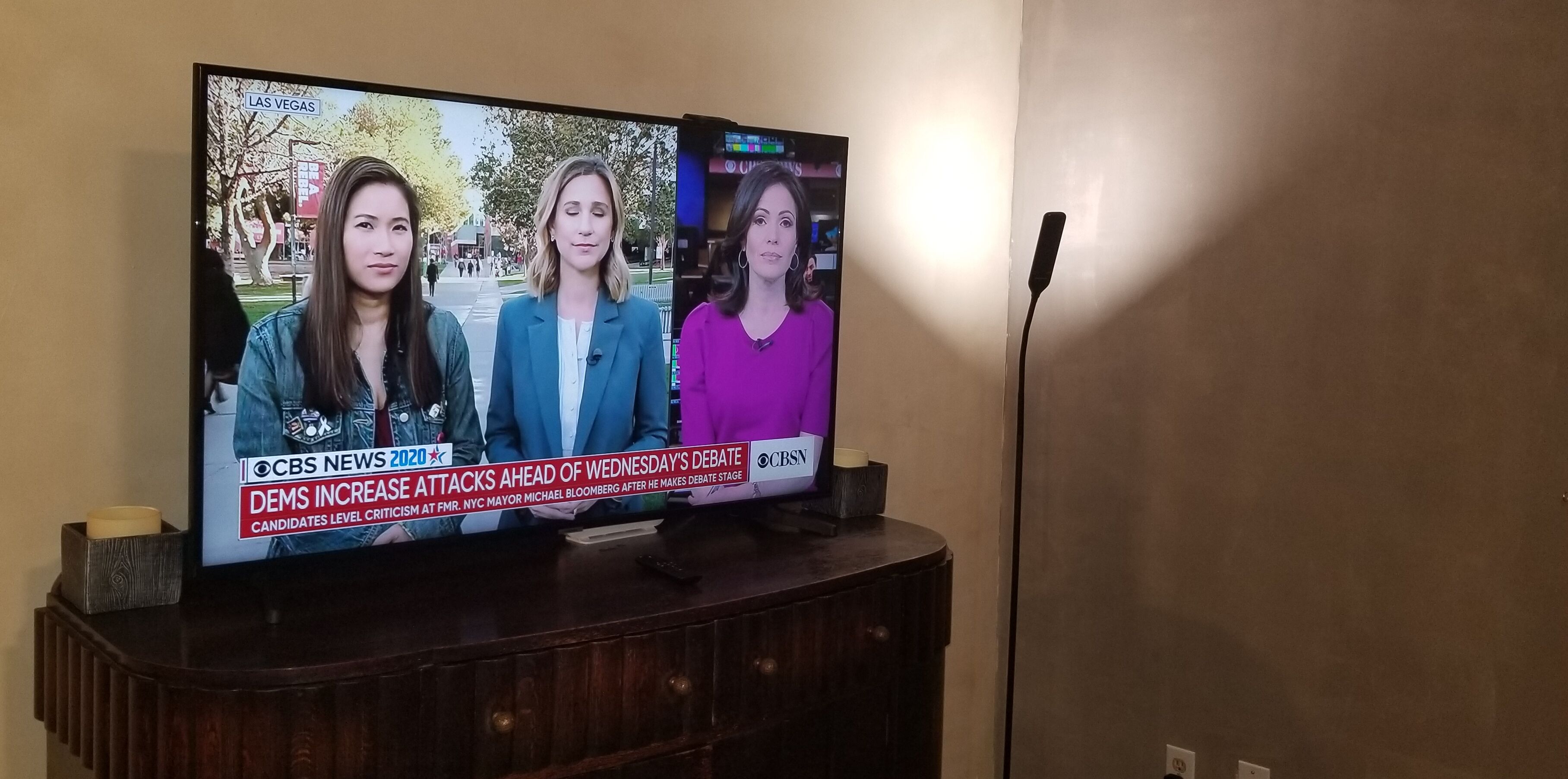 Un televisor mostrando un noticiero con tres presentadores.