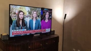 Un televisor mostrando un noticiero con tres presentadores.