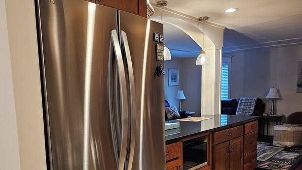 A modern kitchen with stainless steel appliances, wooden cabinets, and a tiled floor. - Newly updated,close to downtown and the lake, pet friendly  (Grand Haven)
