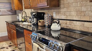 A modern kitchen with wooden cabinets, a stainless steel stove, and a tiled backsplash. - Newly updated,close to downtown and the lake, pet friendly  (Grand Haven)