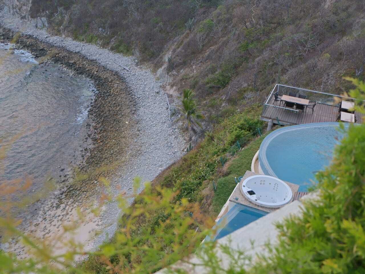 Zona de piscina con jacuzzi, terraza y vistas a la playa.