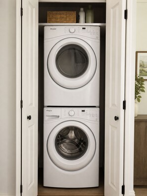 Une buanderie dotée de deux portes et de deux lave-linge Whirlpool à chargement frontal.