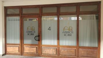 A hotel entrance with frosted glass doors, wooden frames, and the name 'Alistadhotel Bachbrau' on each door.