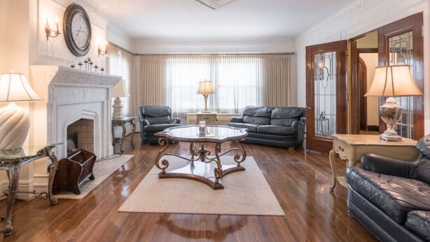 A spacious living room with a fireplace, leather sofas, and a large coffee table. - A beautiful historic property in Downtown Detroit on the river side! Welcome FC! (Detroit)