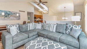 A modern living room with a sectional sofa, pendant lights, and a ceiling fan. - Beautiful home, quiet neighborhood w hot tub. Close to shopping, beach & trails. (Holland)