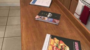 A kitchen with a wooden table, a cookbook titled 'MUNCHIES', and a window with blinds. - Stocked home close to Yale, in Heart of New Haven (New Haven)