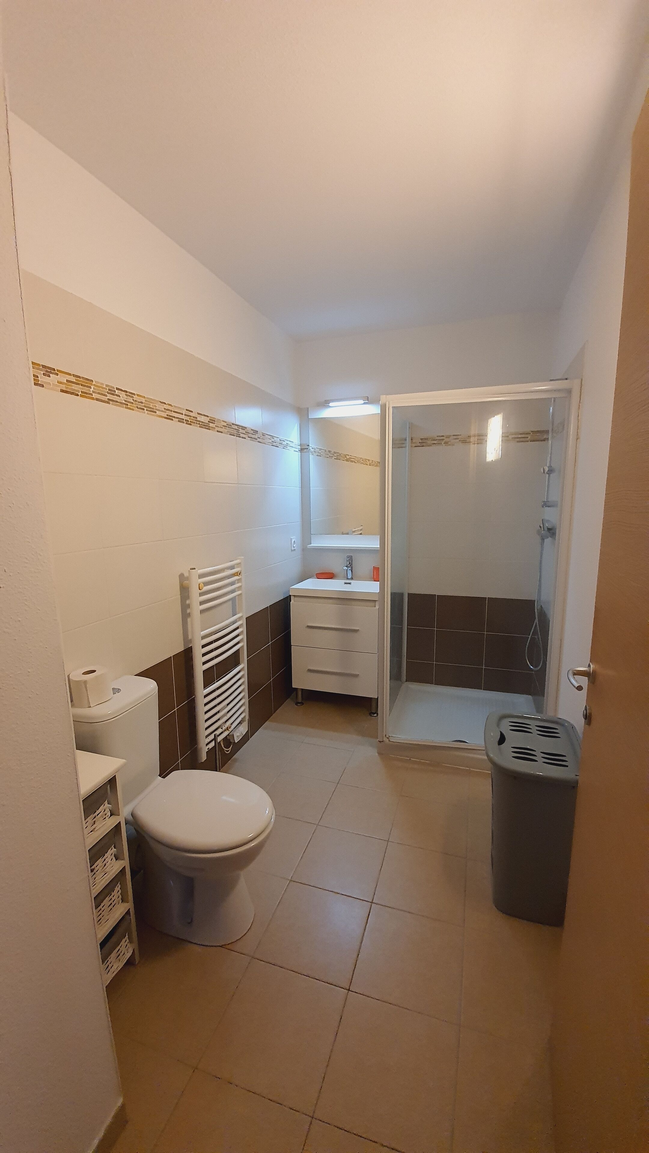 A compact bathroom with a toilet, sink, and shower.