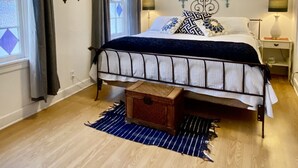 A bedroom with a bed, a ceiling fan, a nightstand, a lamp, and a window with curtains. - ★ Church House ★UNIQUE 2bd converted historic Wallace chapel, walk to everything (Wallace)