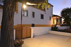 A two-story house with a white exterior and a wooden gate.