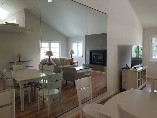 A spacious living area with a dining table, chairs, a sofa, and a fireplace.