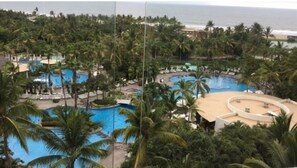 Surrounded by lush greenery and palm trees, this resort offers a serene beachside setting with multiple pools and a scenic ocean view.