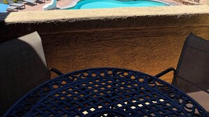 Zona de piscina con sillas de descanso, una piscina pequeña y vista al océano.
