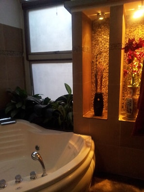 Bathroom features a bathtub and a shelf with a vase.