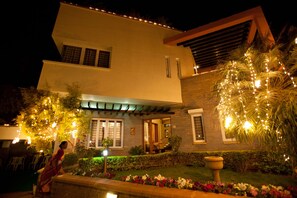 Stunning two-story building with a flat roof and overhang, featuring large windows and a beautifully maintained garden.