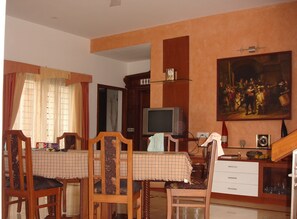 Enjoy meals with family and friends at this dining area, featuring a large table and comfortable seating for four.