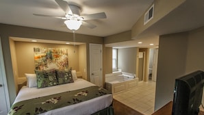 A hotel room with a bed, a ceiling fan, a painting, a bathroom with a bathtub, and a television. - NEW! Christmas week in Branson 2 BR/3 BA/sleeps 8, indoor pool, 1486 sq ft (Branson)