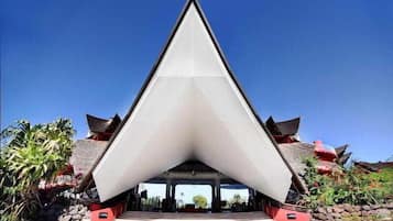 Un bâtiment moderne doté d’une structure de toit triangulaire et d’éléments architecturaux traditionnels.