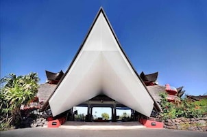 A modern building with a triangular roof structure and traditional architectural elements.