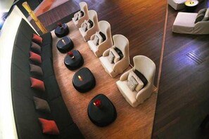 A room with a curved sofa and multiple massage chairs arranged in a row. - Tahiti Ia Ora Beach Resort (Punaauia)