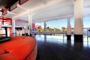 A spacious, modern interior with a red seating area, large windows, and a view of the outdoors.