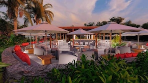 An outdoor seating area with umbrellas, sofas, and tables. - Tahiti Ia Ora Beach Resort (Punaauia)