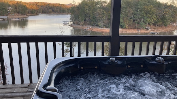 A hot tub on a wooden deck overlooking a lake with boats and a dock. - Lakefront Gem, Mtn views, dock + HOT TUB (Blairsville)