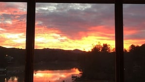 A sunset over a body of water with a reflection, viewed through window frames. - Lakefront Gem, Mtn views, dock + HOT TUB (Blairsville)