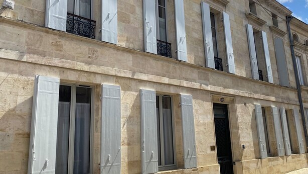 A multi-story building with large windows and shutters, featuring a stone facade and a flat roof. - Maison St Romain (Blaye)