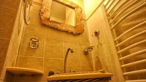 A bathroom with a bathtub, a sink, and a mirror with a rustic frame. - Triantafillies Hotel (Volos)