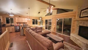A log cabin interior with a living room, kitchen, and dining area. - Mountain Sunrise Cabin with breathe taking views. (Divide,)