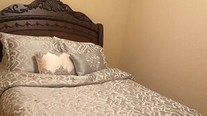 A bed with a dark wooden headboard and a patterned bedspread. - Mountain Sunrise Cabin with breathe taking views. (Divide,)