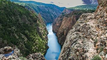 Un cañón con un río, rodeado de colinas boscosas.
