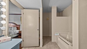 A bathroom with a bathtub, a toilet, and a shower area.