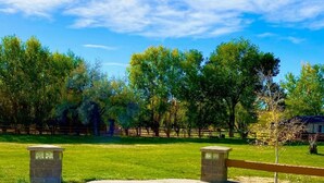 A grassy park with trees and a wooden fence. - Red Arrow Inn & Suites, a Travelodge by Wyndham (Montrose)