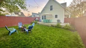 A backyard with a wooden deck, a barbecue grill, and outdoor seating with chairs. - Lake Erie Getaway Near The Beach & Cedar Point (Huron,)