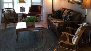 A living room with a brown leather sofa, two armchairs, a coffee table, and a floor lamp. - Air Bellows Gap Retreat (Sparta)