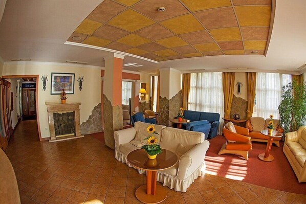 Un amplio salón con chimenea, sofás y una mesa de centro redonda.