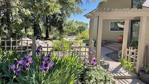 A garden with purple flowers and a wooden fence. - Spacious South Hill View Home, Private Mountain Setting & Hot Tub (Spokane)