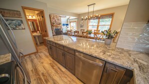 A kitchen with a granite countertop, wooden cabinets, and a dishwasher. - Snake River 1 (Keystone)