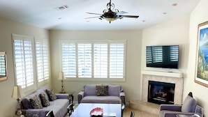 A spacious living room with a dining area, a fireplace, and a ceiling fan. - Carlsbad Village, Great Beach Access, Shops & Restaurants (Carlsbad)