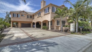 A two-story house with a covered driveway, palm trees, and a signboard. - Carlsbad Village, Great Beach Access, Shops & Restaurants (Carlsbad)