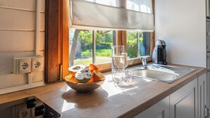 A kitchen with a window, a bowl of fruit, glasses, and a kettle. - Rural las Bodegas Setenil de las Bodegas by Ruralidays (Cádiz)