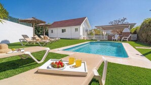 A backyard with a swimming pool, lounge chairs, a house, and a white picket fence. - Rural las Bodegas Setenil de las Bodegas by Ruralidays (Cádiz)