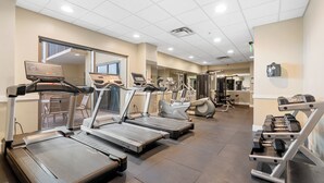 Una palestra con tapis roulant, ellittiche e attrezzi per pesi.